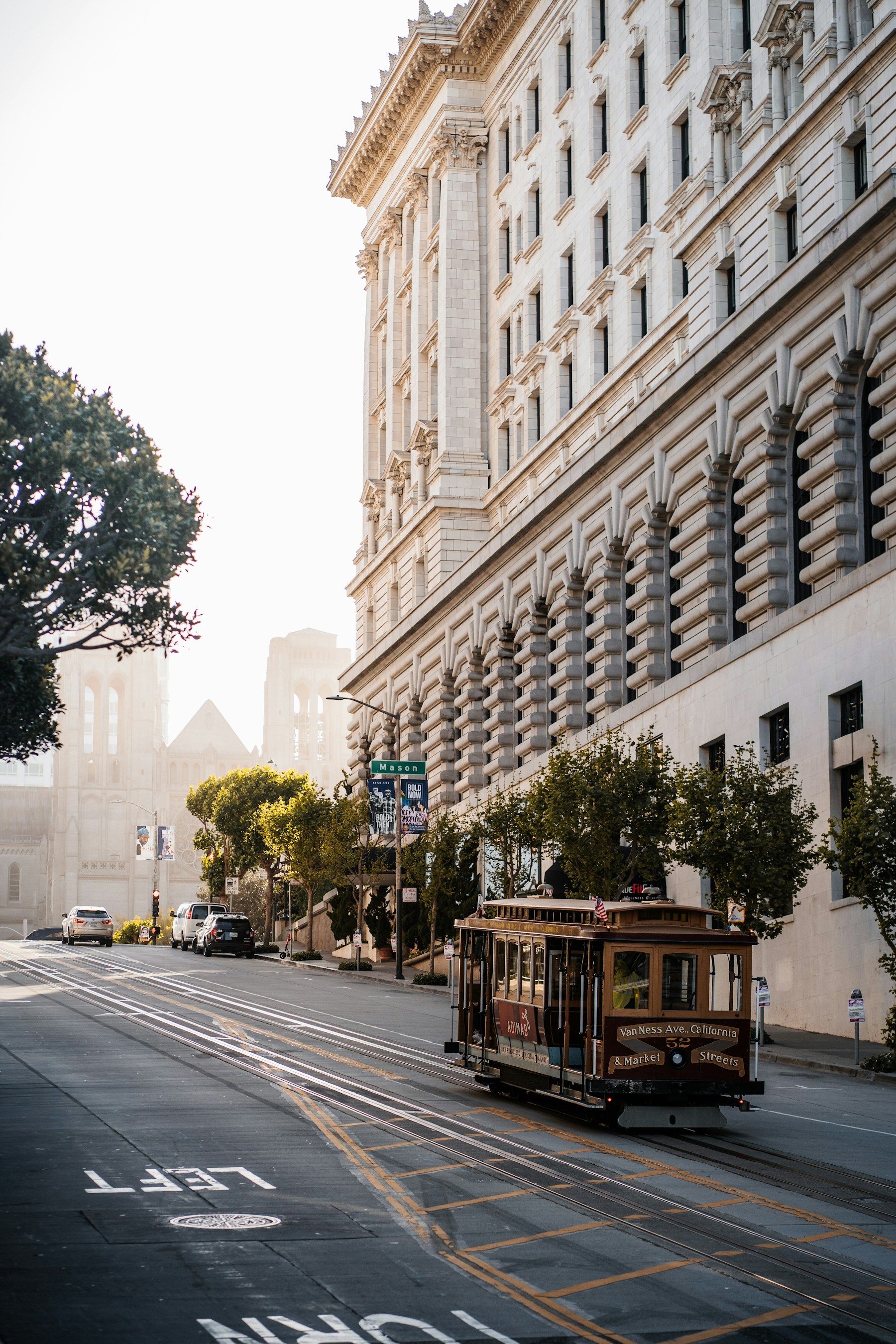 A cable car on a sunlit San Francisco street
